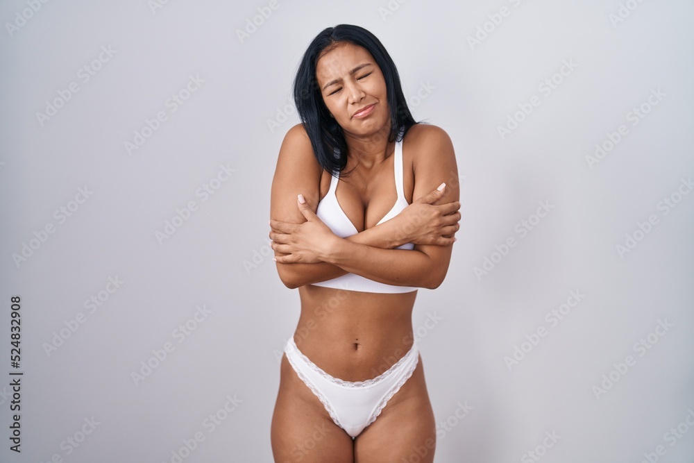 Hispanic woman wearing lingerie shaking and freezing for winter cold with sad and shock expression on face Hispanic woman wearing lingerie shaking and freezing for winter cold with sad and shock expression on face