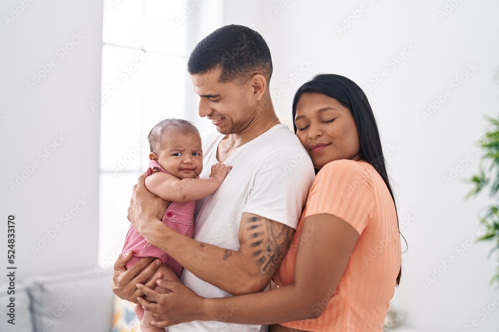 Hispanic family hugging each other standing at home Hispanic family hugging each other standing at home