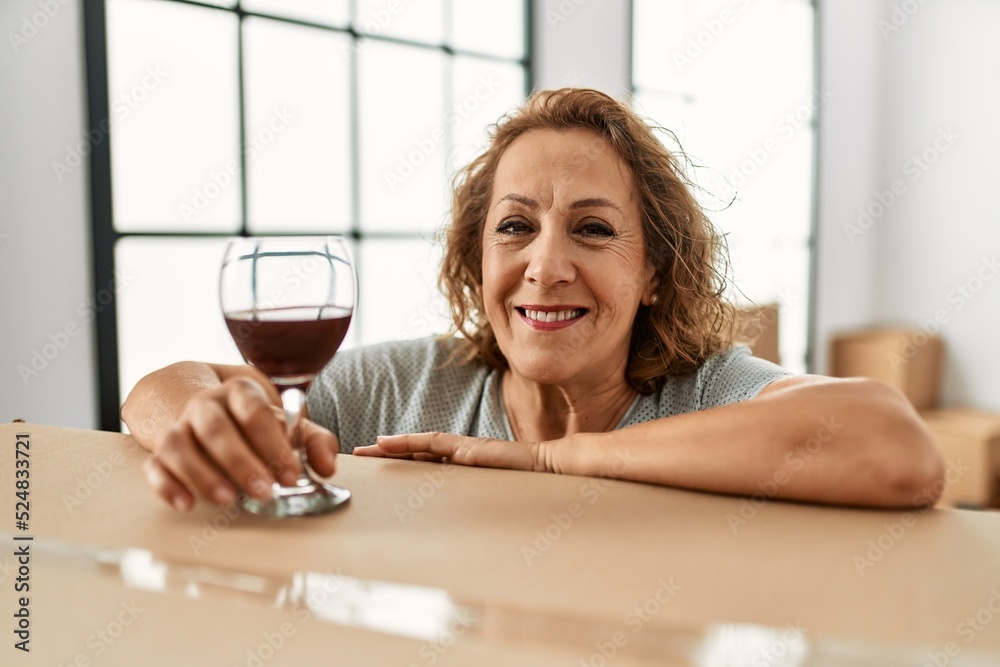 Middle age caucasian woman smiling happy drinking wine at new home. Middle age caucasian woman smiling happy drinking wine at new home.
