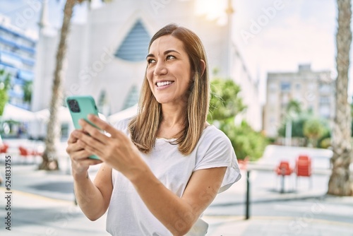 Free Download Young hispanic woman smiling confident using smartphone at street - GFXLoad