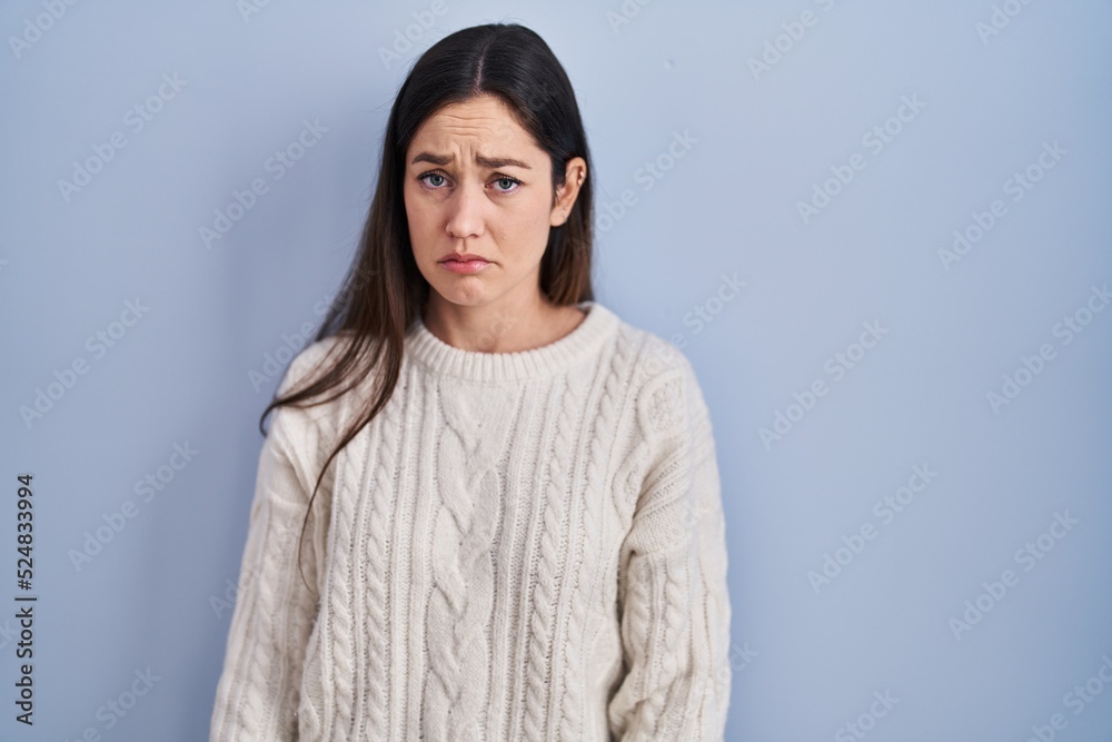 Young brunette woman standing over blue background depressed and worry for distress, crying angry and afraid. sad expression. Young brunette woman standing over blue background depressed and worry for distress, crying angry and afraid. sad expression.
