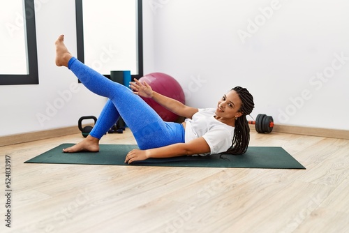 Young african american woman smiling confident training abs exercise at sport center