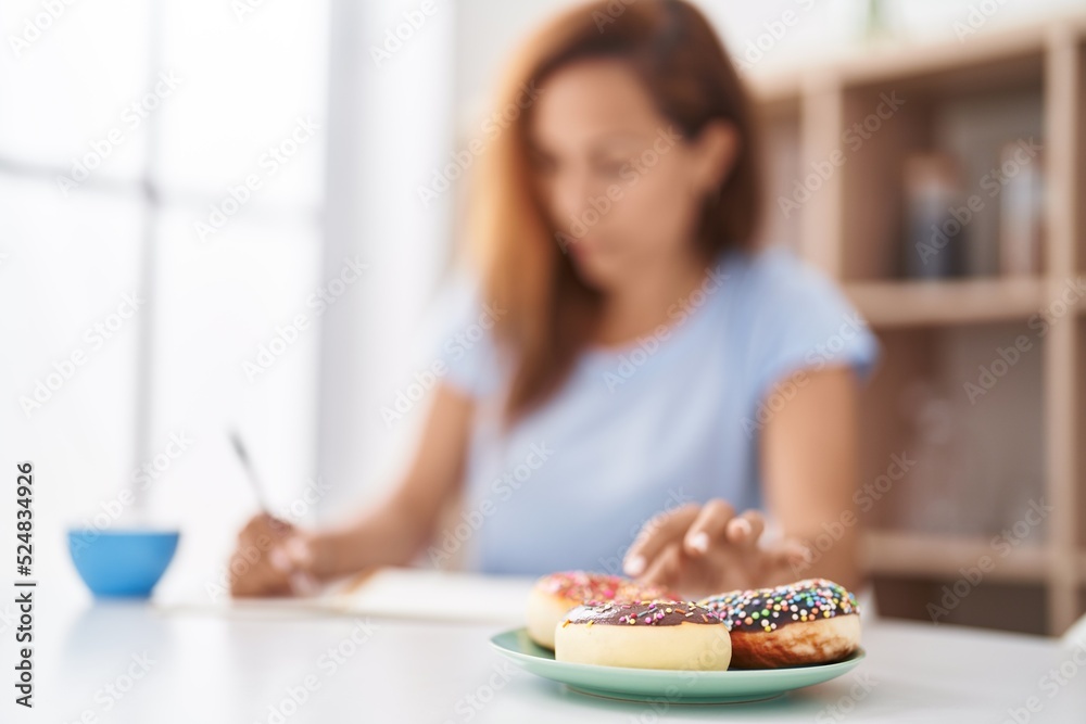 Young woman write on notebook having breakfast at home Young woman write on notebook having breakfast at home