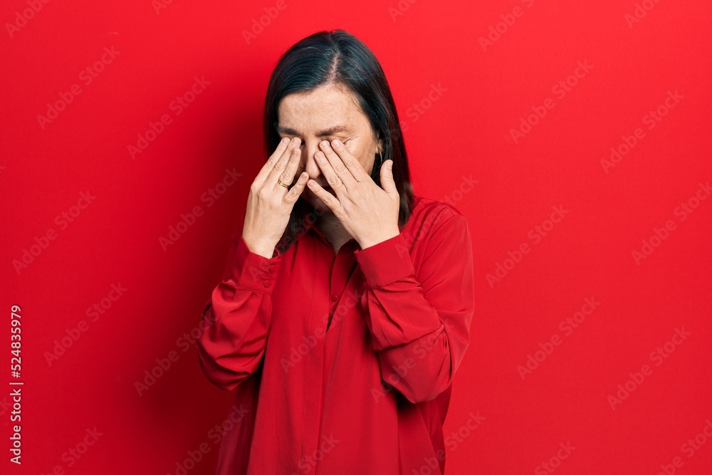 Middle age hispanic woman wearing casual clothes rubbing eyes for fatigue and headache, sleepy and tired expression. vision problem Middle age hispanic woman wearing casual clothes rubbing eyes for fatigue and headache, sleepy and tired expression. vision problem