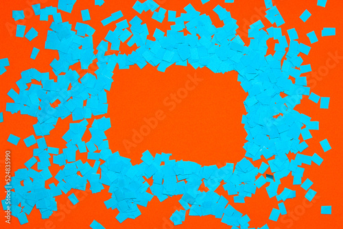 frame of shredded blue torn paper on orange background, copy space, creative design with complementary colors
 photo