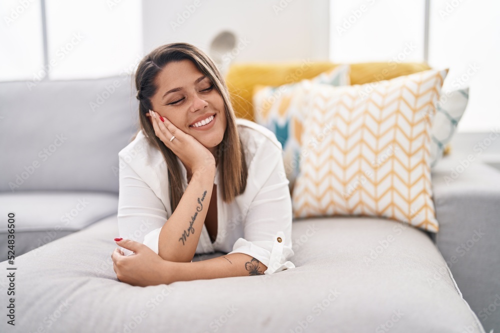 Young hispanic woman smiling confident lying on sofa at home Young hispanic woman smiling confident lying on sofa at home