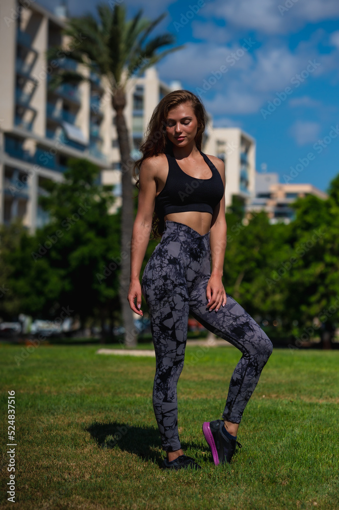 Fashion fitness model posing outside in leggings and top.