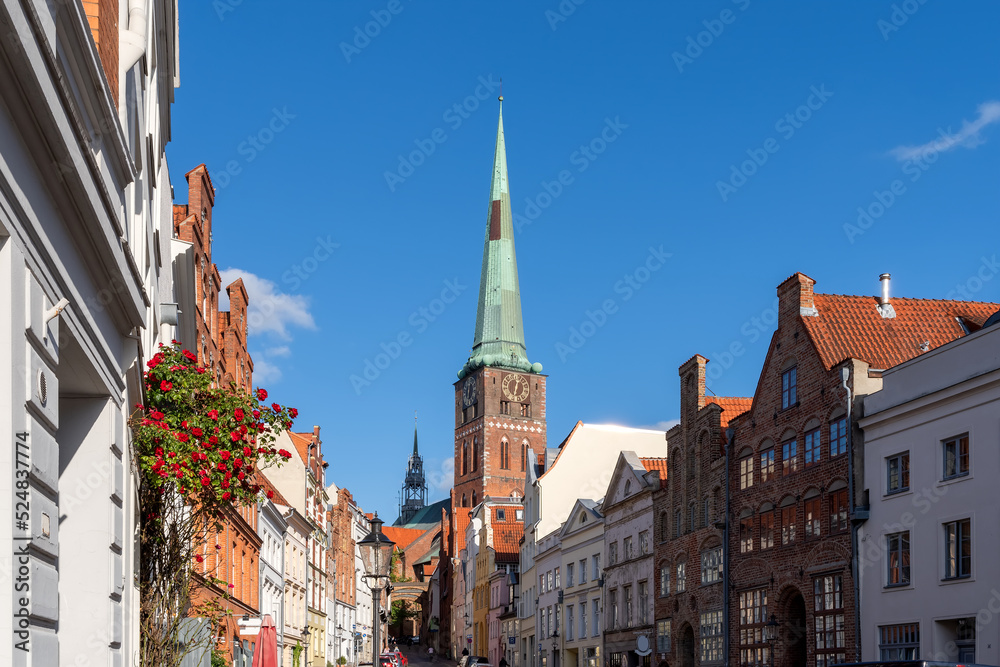 Street in Lübeck with tradional buildings und view to the tower of the church St. Jakobi