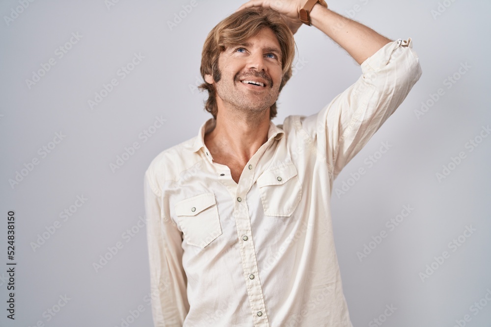 Middle age man standing over isolated background smiling confident touching hair with hand up gesture, posing attractive and fashionable Middle age man standing over isolated background smiling confident touching hair with hand up gesture, posing attractive and fashionable