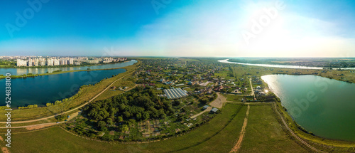 Fototapeta Naklejka Na Ścianę i Meble -  aerial view over the outskirts of the Adyghe aul Starobzhegokai and the Muslim cemetery located between the lakes on a sunny summer day