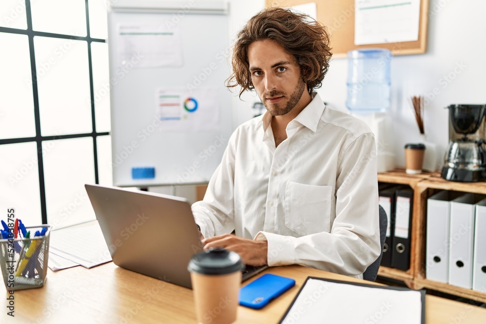 Young hispanic businessman with relaxed expression working at office. Young hispanic businessman with relaxed expression working at office.