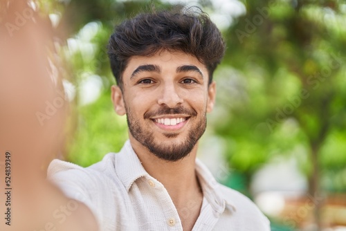 Young arab man smiling confident making selfie by the camera at park