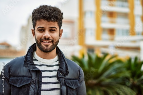 Fotografie, Obraz Young arab man smiling outdoor at the town