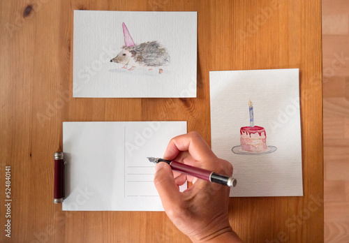 Flatlay: Hand writing birthday card with watercolor hedgehog photo