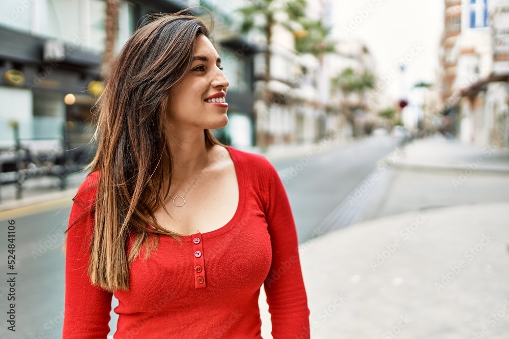 Young hispanic girl smiling happy standing at the city.