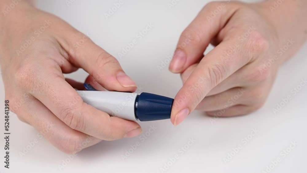 Caucasian woman doing a glucose test using a pen lancet. Caucasian woman doing a glucose test using a pen lancet.