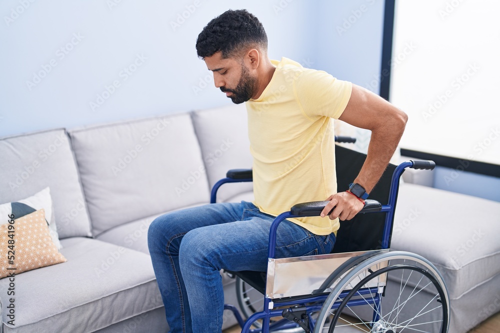 Young arab man sitting on wheelchair at street Young arab man sitting on wheelchair at street