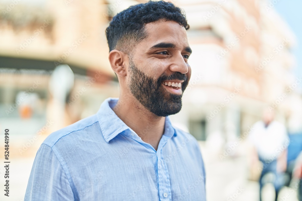 Young arab man smiling confident looking to the side at street Young arab man smiling confident looking to the side at street