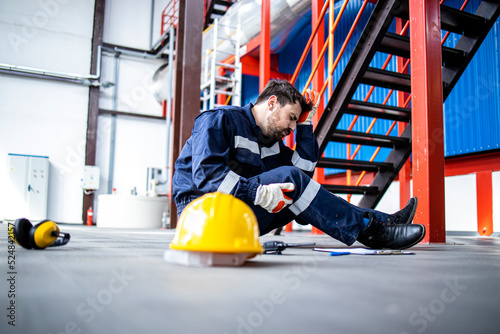 Refinery worker got himself injured during work sitting on the floor having head pain. photo