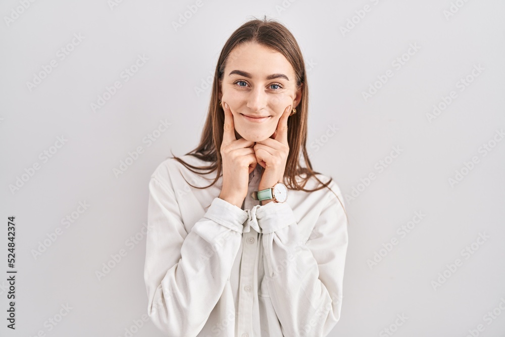 Young caucasian woman standing over isolated background smiling with open mouth, fingers pointing and forcing cheerful smile Young caucasian woman standing over isolated background smiling with open mouth, fingers pointing and forcing cheerful smile