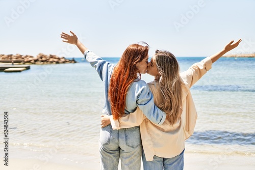 Young lesbian couple of two women in love at the beach. Beautiful women together at the beach in a romantic relationship
