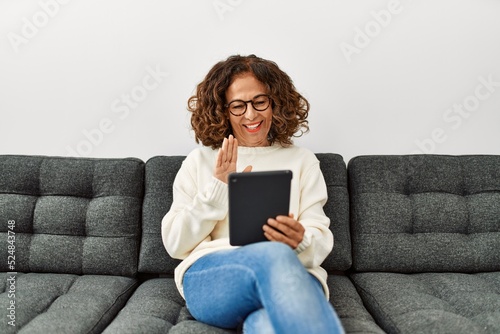 Middle age hispanic woman smiling confident having video call at home