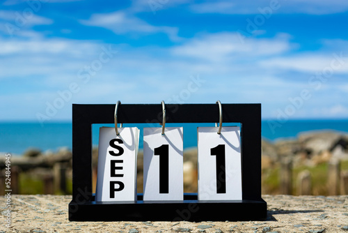 Sep 11 calendar date text on wooden frame with blurred background of ocean. photo