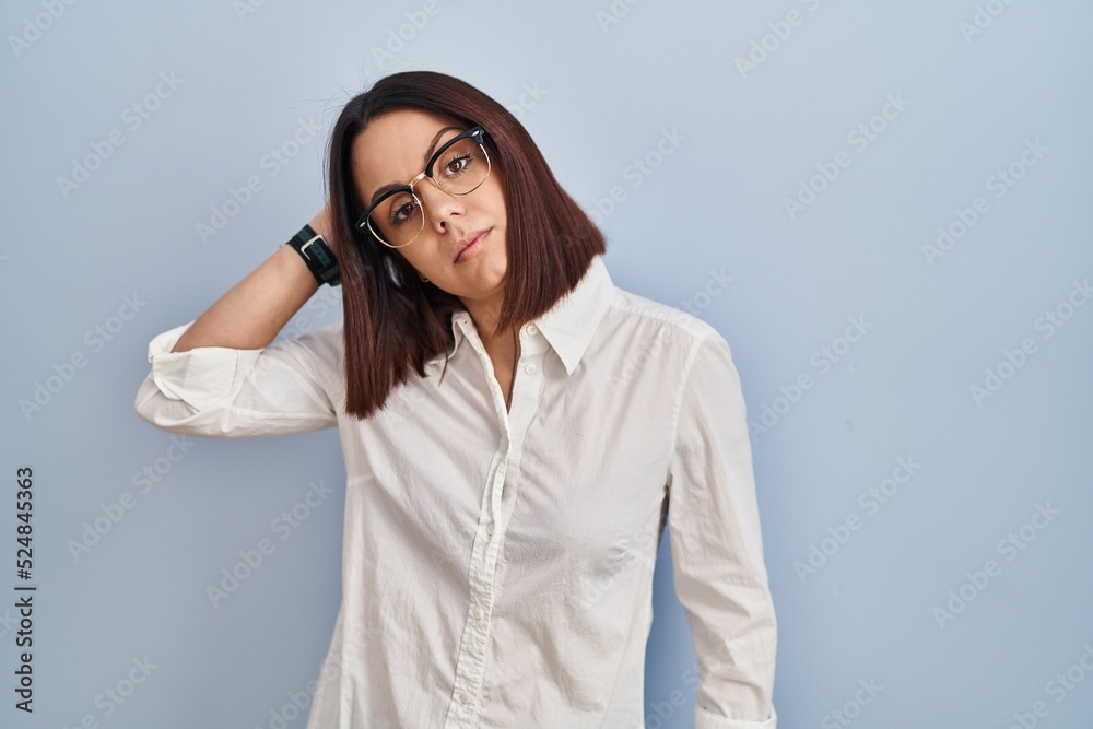 Young hispanic woman standing over white background confuse and wondering about question. uncertain with doubt, thinking with hand on head. pensive concept.