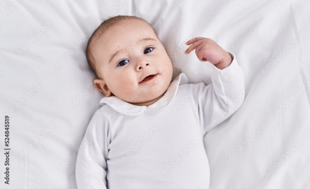 Adorable baby smiling confident lying on bed at bedroom Adorable baby smiling confident lying on bed at bedroom