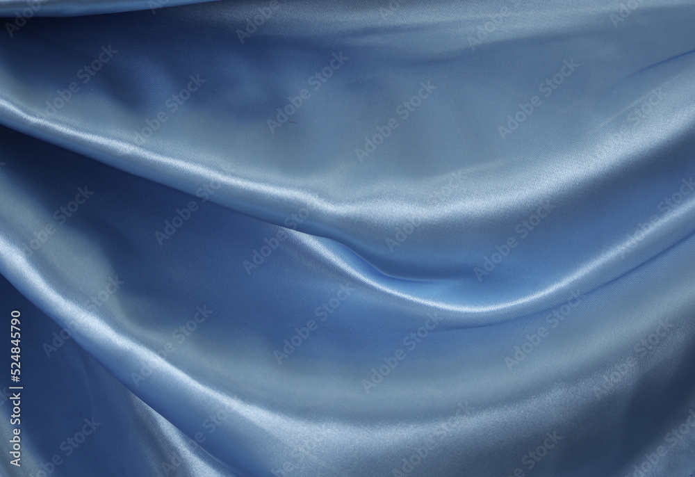 blue wave curtain and soft shadows. Beautiful rippled textile fabric. Luxurious. Soft, light, fluttery blue fabric texture. Abstract background on isolated.