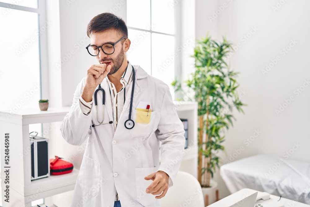 Hispanic man wearing doctor uniform and stethoscope feeling unwell and coughing as symptom for cold or bronchitis. health care concept. Hispanic man wearing doctor uniform and stethoscope feeling unwell and coughing as symptom for cold or bronchitis. health care concept.