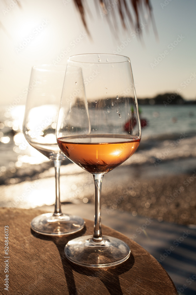 Two glasses of rose wine against the sunset sky.