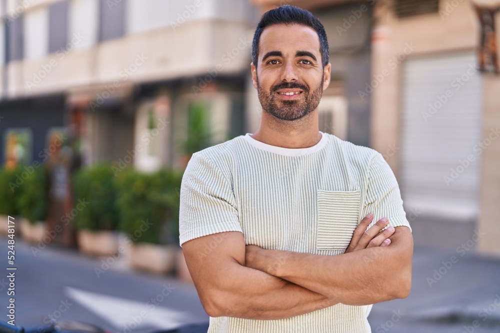 Young hispanic man smiling confident standing with arms crossed gesture at street Young hispanic man smiling confident standing with arms crossed gesture at street