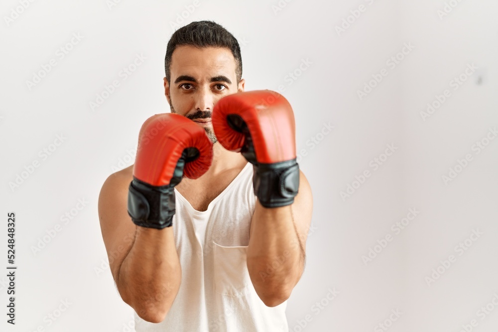 Young hispanic man boxing over isolated white background Young hispanic man boxing over isolated white background