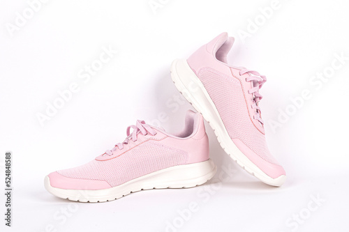 Light pink running sports shoe on white background. Running shoe, sneaker or trainer. Women's athletic shoe. fitness, sport, training concept.