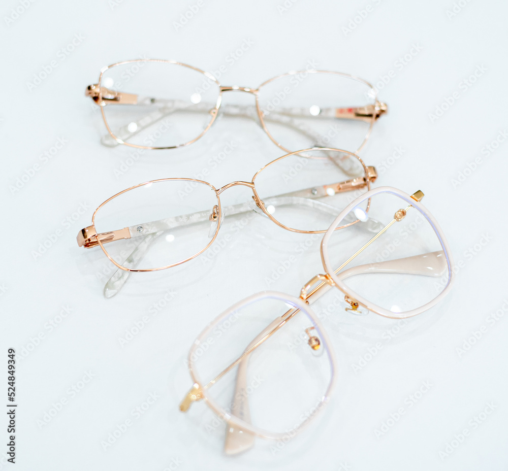 gold-rimmed eyeglasses lie on a white table gold-rimmed eyeglasses lie on a white table
