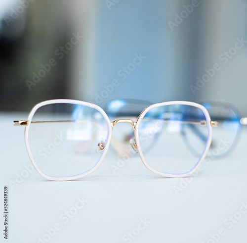 gold-rimmed eyeglasses lie on a white table
