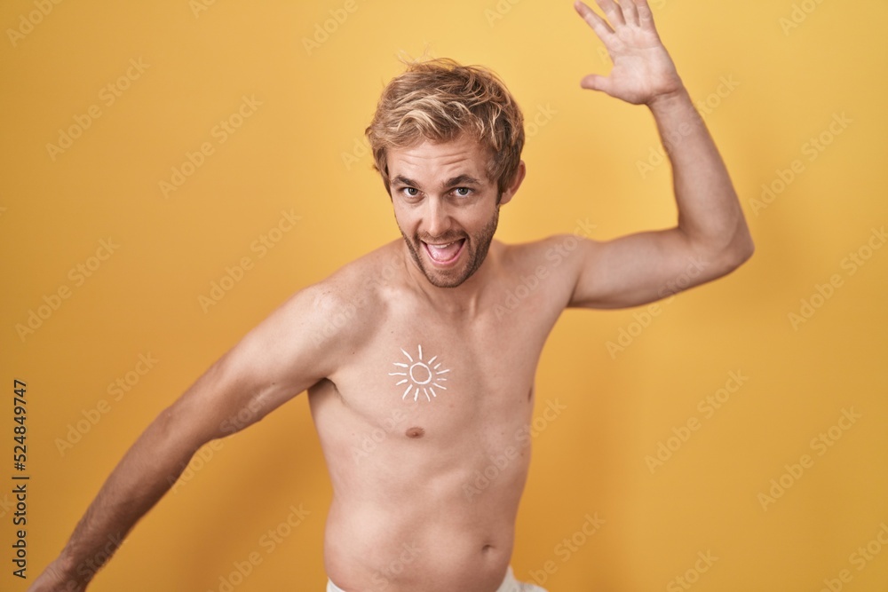 Caucasian man standing shirtless wearing sun screen dancing happy and cheerful, smiling moving casual and confident listening to music Caucasian man standing shirtless wearing sun screen dancing happy and cheerful, smiling moving casual and confident listening to music