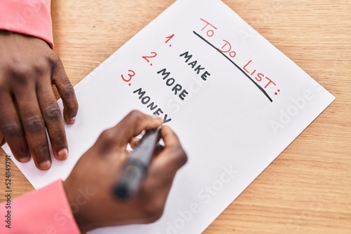 African american woman business worker writing to do list at office