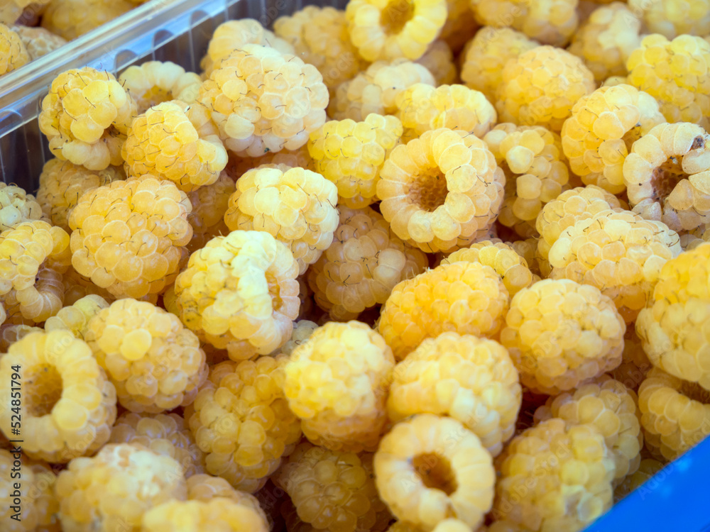 Yellow raspberries in a plastic tray Yellow raspberries in a plastic tray