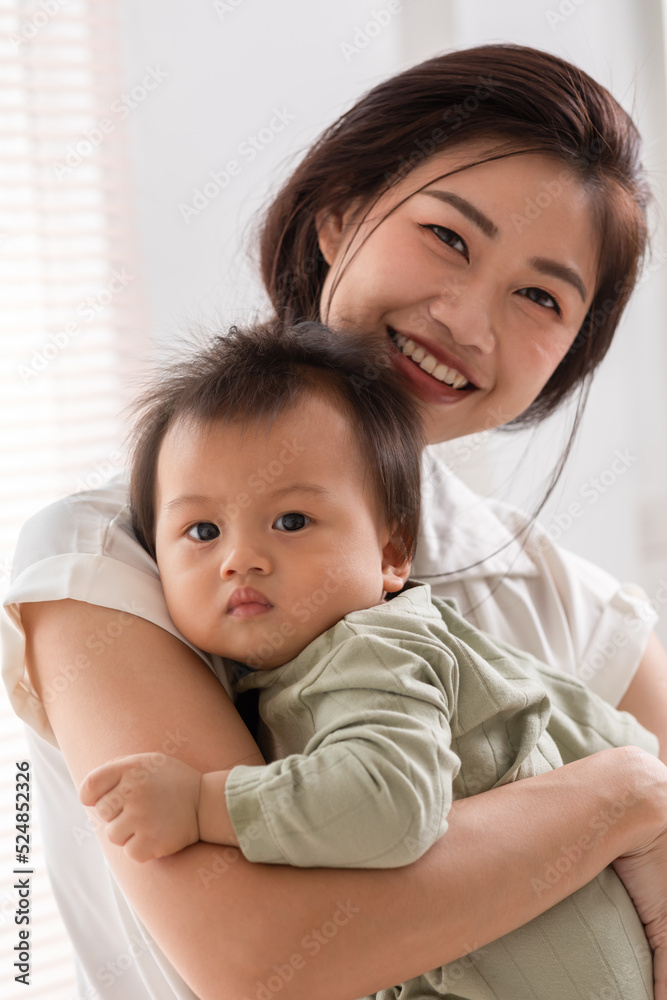 Happy asian mom playing and spending time with her newborn baby and looking at camera together at home.Adorable baby boy smile laughing with mother in warmth place relax and comfortable.good moment Happy asian mom playing and spending time with her newborn baby and looking at camera together at home.Adorable baby boy smile laughing with mother in warmth place relax and comfortable.good moment