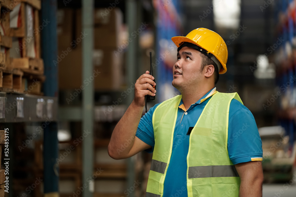 Asian salesperson, check stock and use radio for warehouse communication, business idea Asian salesperson, check stock and use radio for warehouse communication, business idea