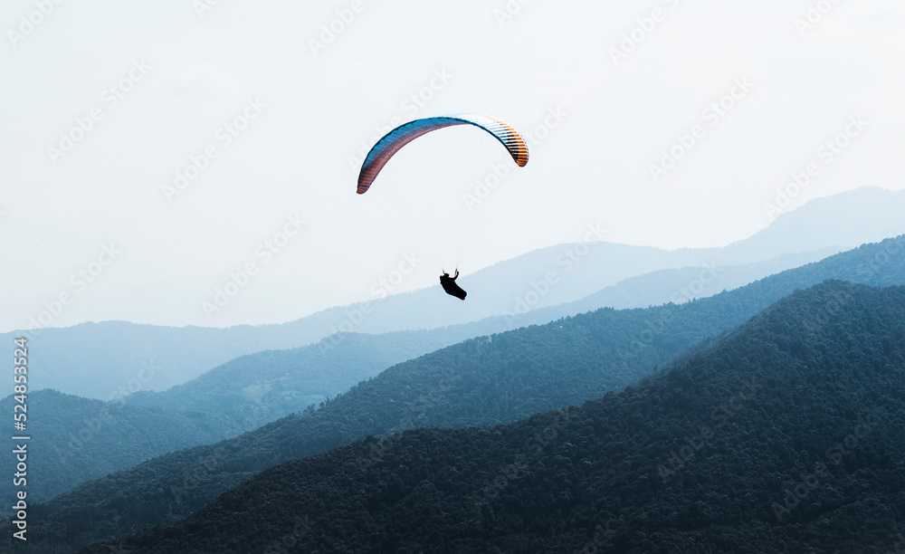 Man doing paragliding flight in the italian mountains Man doing paragliding flight in the italian mountains