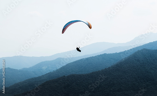 Man doing paragliding flight in the italian mountains