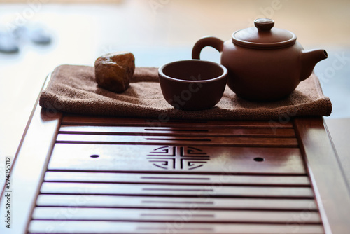 Teapot and tea cup made of yixing clay stands on a bamboo tea tray. Chinese traditional gongfu cha teaware photo