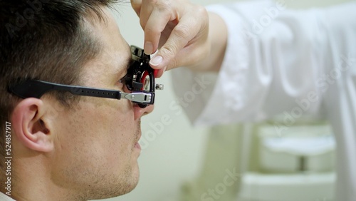Consultation with an ophthalmologist. face close-up , ophthalmologist examining patient man with optometrist trial frame, Medical equipment. Coreometry. High quality photo photo