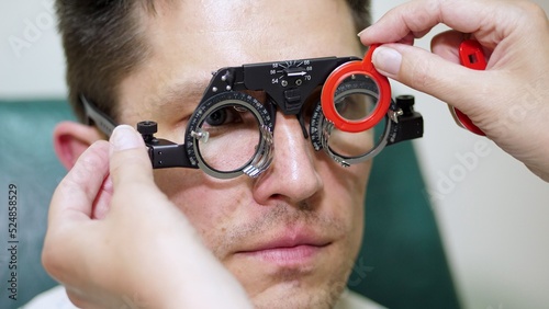 face close-up , ophthalmologist examining patient man with optometrist trial frame, visual inspection device. male patient to check vision in ophthalmological clinic,. High quality photo photo