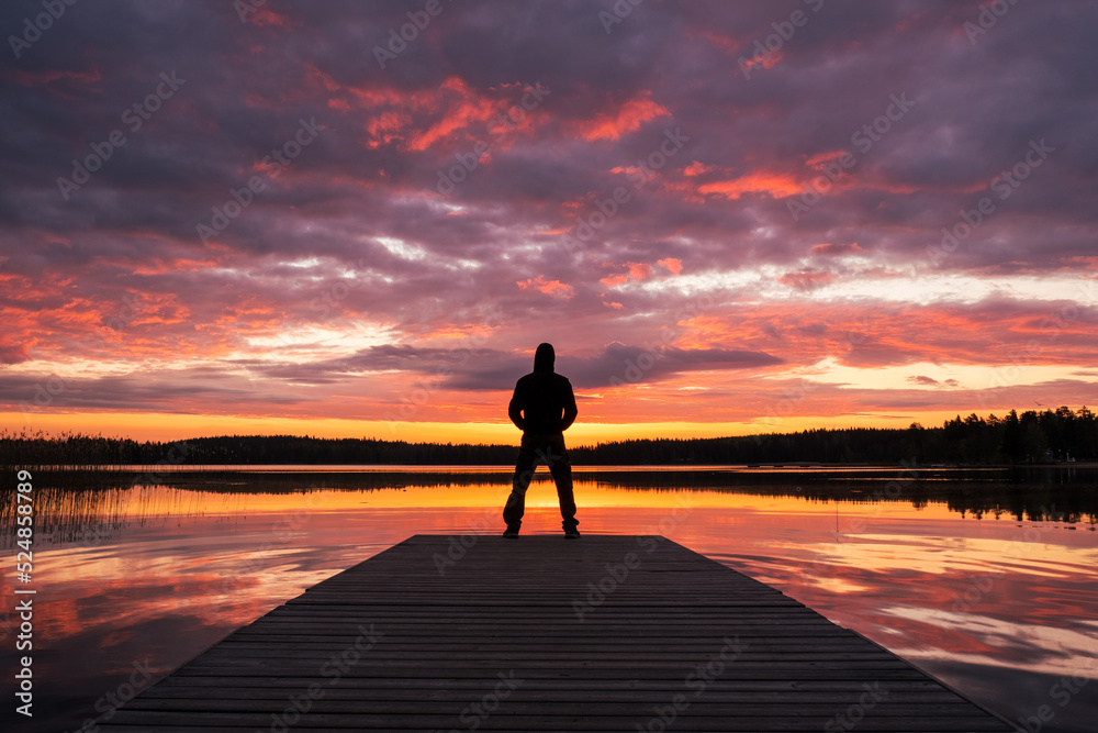 silhouette of a person standing on the pier at sunrise silhouette of a person standing on the pier at sunrise