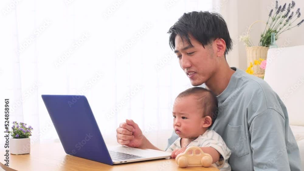 赤ちゃんとノートパソコンを見る父親 赤ちゃんとノートパソコンを見る父親