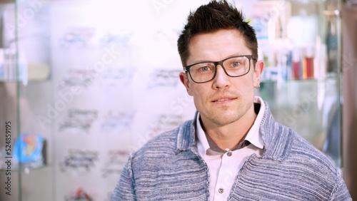 portrait of Handsome young man choosing eyeglasses special frame with transparent and dark sun glasses, in optical store. shop glasses, optics, optician retail store. High quality photo